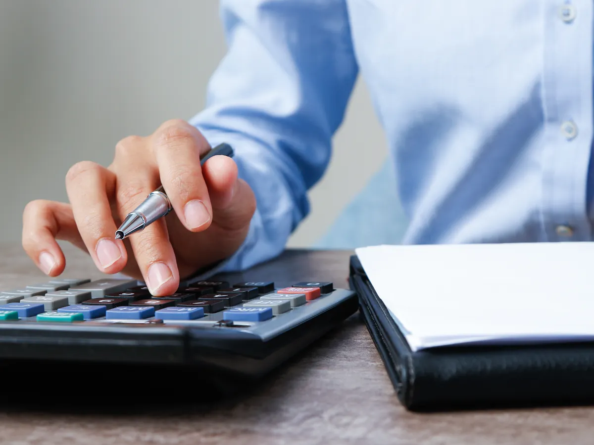 Contador calculando impuestos con calculadora y documentos