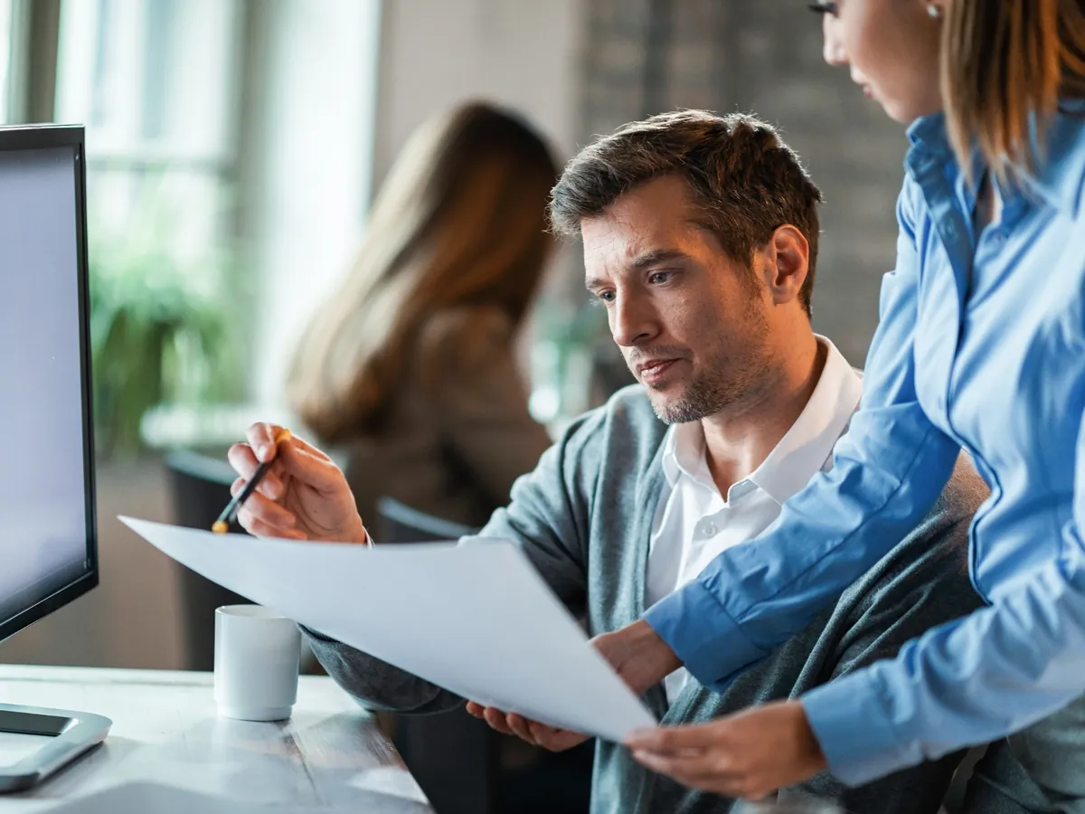 Dos auditores revisando estados financieros impresos en una oficina